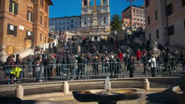 ローマ イタリア 2024 日光でボートのバロック様式の噴水の近くのスペインのステップを歩く観光客 バックグラウンドのサンティマ トリニティ モンティ教会 — ストック動画