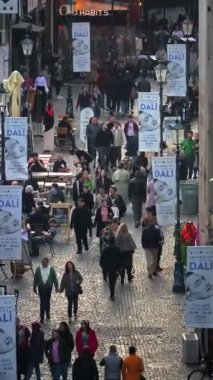 Bükreş, Romanya - 03 Mart 2024: Eski kentteki tarihi binalar ve ticari dükkanlar arasında yürüyen insanların dikey hava aracı görüntüsü