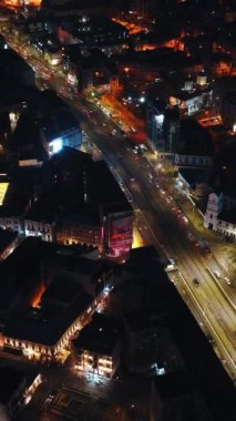Bükreş, Romanya - 03 Mart 2024: Geceleri aydınlanan şehir manzarasının dikey hava aracı görüntüsü. Trafiği yolda hareket ettiriyor