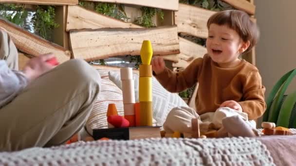 Mężczyzna Bawiący Się Dzieckiem Kolorowymi Drewnianymi Zabawkami Łóżku — Wideo stockowe