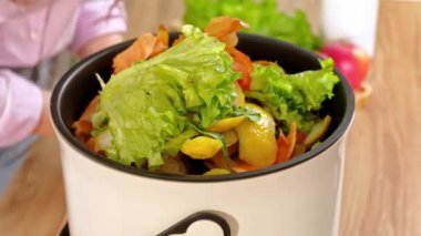 Mutfaktaki Bokashi 'de sebze kabuğu soyarak organik atıkları geri dönüştürüyor.