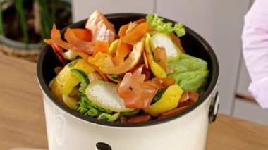 Mutfaktaki Bokashi 'de sebze kabuğu soyarak organik atıkları geri dönüştürüyor.