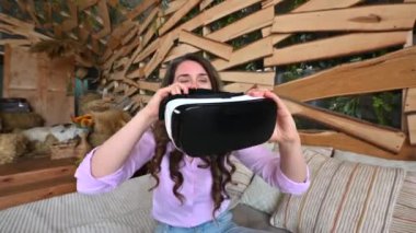 Kadın VR kulaklığı takıyor ve eğleniyor.