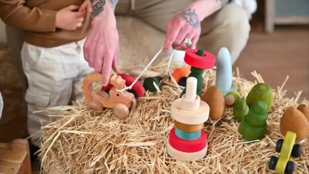 Πατέρας Παίζει Γιο Του Πολύχρωμα Οικολογικά Ξύλινα Παιχνίδια Έναν Αχυρώνα — Αρχείο Βίντεο