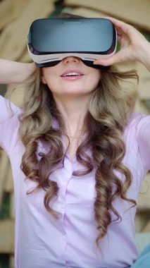 Kadın VR kulaklığı takıyor ve bundan zevk alıyor. Dikey
