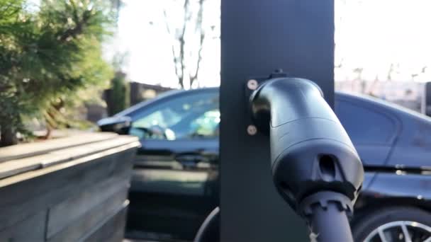 电动汽车充电器特写 车上有一只小昆虫 背景是黑色的 — 图库视频影像