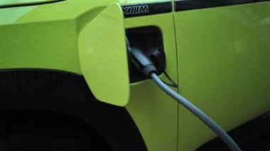 Chisinau, Moldova - 28 Mart 2024: Yağmurda şarj olan yeşil elektrikli bmw arabaya yakın çekim