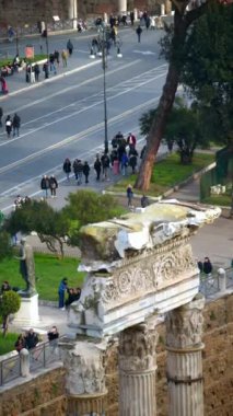 Roma, İtalya - 16 Şubat 2024: Arka planda yürüyen insanların olduğu Antik Roma kalıntıları. Dikey