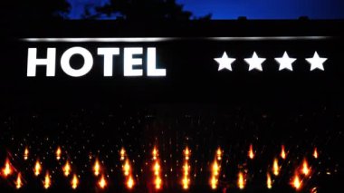 Geceleri turuncu ışıklı beyaz neon 4 yıldızlı otel tabelası.