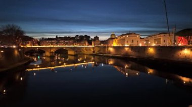Roma, İtalya - 16 Şubat 2024: Sant 'Angelo Köprüsü Tiber Nehri' nin karşısındaki şehir manzaralı gece