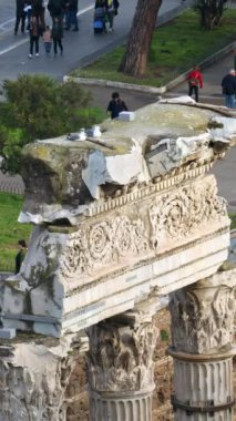 Roma, İtalya - 16 Şubat 2024: Arka planda yürüyen insanların olduğu Antik Roma kalıntıları. Dikey