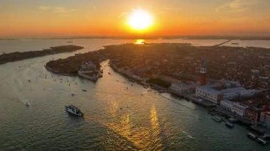 Günbatımında İtalya 'nın Venedik şehrinde hareket eden teknelerin hava görüntüsü