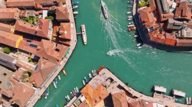 Tekneler Murano, Venedik, İtalya 'da bir kanalda hareket ediyor.