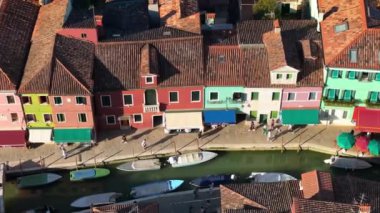 İtalya 'nın Burano Adası' ndaki renkli evlerin yakınındaki bir kanalın kenarındaki teknelerin hava manzarası.