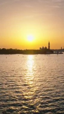 Gün batımında Venedik Şehri 'ni çevreleyen suyun insansız hava aracı görüntüsü. Dikey