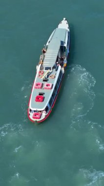 Venedik, İtalya 'da gündüz vakti denizde yüzen bir teknenin insansız hava aracı görüntüsü. Dikey