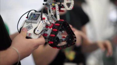 Chisinau, Moldova - 20 Mayıs 2024: Hareket eden bir Lego Mindstorm robotunu analiz eden adam