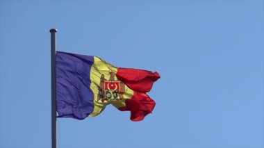 Moldova Cumhuriyeti bayrağı arka planda mavi bir gökyüzü ile sallanıyor, yavaş çekim