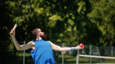 Güneşli bir günde, mavi ve yeşil kortta tenis oynayan iki adam.