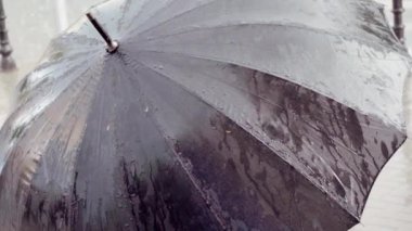 Yağmurda siyah bir şemsiye yakın