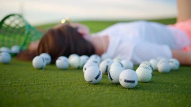 Golf sahasında yatan kadın kovanın yanında taşakları dökülmüş.