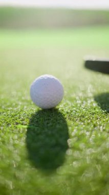 Sahada topa vuran bir golf sopasının yakınında. Dikey