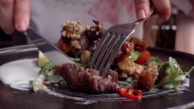 Restoranda dana eti yiyen bir kadın.