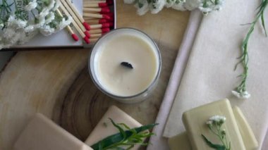 Ahşap bir yüzeydeki beyaz mum ve sabunları kapat.