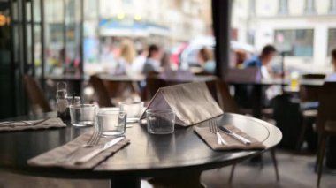 Paris, Fransa 'da bir restoranda, arka planda bulanık insanların yemek yediği bir masa.