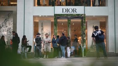 Paris, Fransa - 18 Haziran 2024: Hıristiyan Dior mağazasının önünden geçen insanlar