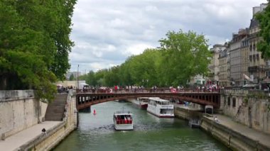 Paris, Fransa - 18 Haziran 2024: Sen Nehri üzerindeki Pont au Double köprüsünün altından geçen tekne