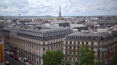 Paris, Fransa - 18 Haziran 2024: Paris, Fransa 'da çevresindeki binalarla Eyfel Kulesi' nin uzak manzarası