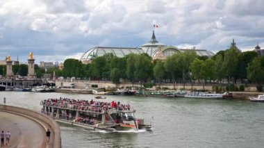 Paris, Fransa - 18 Haziran 2024 Seine nehrinde hareket eden insanlarla dolu bir tekne.