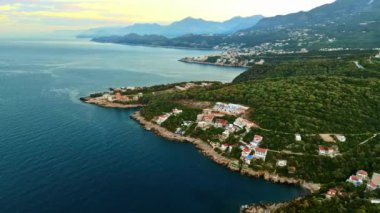 Adriyatik Denizi kıyısında, Karadağ 'ın arka planında dağlar bulunan binaların hava ve insansız hava aracı görüntüsü