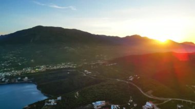 Adriyatik Denizi kıyısında, Karadağ 'ın arka planında dağlar bulunan binaların hava ve insansız hava aracı görüntüsü