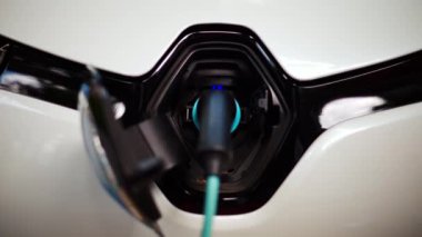 Beyaz elektrikli arabanın şarj olduğu yeri kapat.
