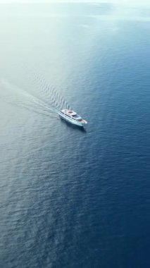 Hırvatistan 'daki Adriyatik Denizi' nde hareket eden beyaz bir teknenin hava ve insansız hava aracı görüntüsü. Dikey