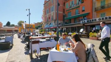 Villefranche sur Mer, Fransa - 5 Temmuz 2024: Fransız Rivierası 'ndaki bir sahil caddesinde masalarda oturan insanlar