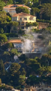 Fransız Rivierası 'ndaki Villefranche-sur-Mer kasabasından duman çıkıyor. Dikey