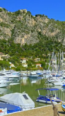 Beaulieu-sur-Mer, Fransa - 8 Temmuz 2024: Beaulieu-sur-Mer limanına yanaşan beyaz botların görüntüsü. Dikey