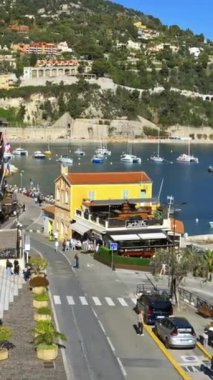 Villefranche sur Mer, Fransa - 8 Temmuz 2024: Fransız Rivierası 'ndaki bir sahil caddesinde masalarda oturan insanlar. Dikey