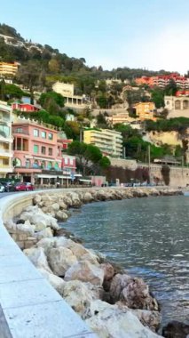 Villefranche sur Mer, Fransa - 8 Temmuz 2024: İnsanlar Fransız Rivierası 'nın deniz kıyısındaki bir kasabasında gündüz vakti sokakta yürüyorlar. Dikey