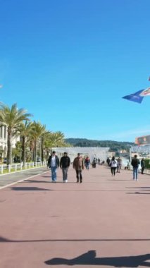 Güzel, Fransa - 7 Temmuz 2024: insanlar sahilde Promenade des Anglais 'de yürüyor. Dikey