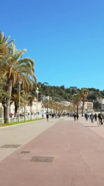 Güzel, Fransa - 7 Temmuz 2024: insanlar sahilde Promenade des Anglais 'de yürüyor. Dikey