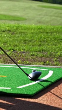 Golf sopasının yakını golf topunu deliğe vuruyor. Dikey