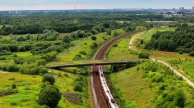 Demiryollarında bir şehre doğru giden trenin insansız hava aracı görüntüsü
