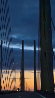 Öresund Köprüsü 'nün Öresund Boğazı boyunca uzanan ve gün batımında İsveç ile Danimarka arasında kalan köprü manzarası. Dikey