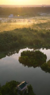 Moldova 'nın Chisinau kentindeki ağaçlarla çevrili bir gölün hava aracı görüntüsü. Dikey