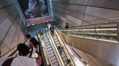 Kopenhag, Danimarka - 24 Temmuz 2024: Kongens Nytorv metro istasyonundaki yürüyen merdivenlerdeki insanlar