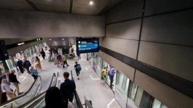 Kopenhag, Danimarka - 24 Temmuz 2024: Kongens Nytorv metro istasyonundaki yürüyen merdivenlerdeki insanlar